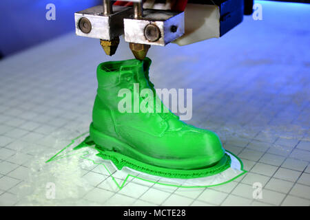 3D printer prints the form of molten plastic green close-up. Automatic three dimensional 3d printer performs plastic modeling in laboratory. Progressi Stock Photo