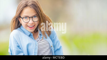 Portrait of happy smilling teenage young girl with glasses and beautiful smile. Stock Photo