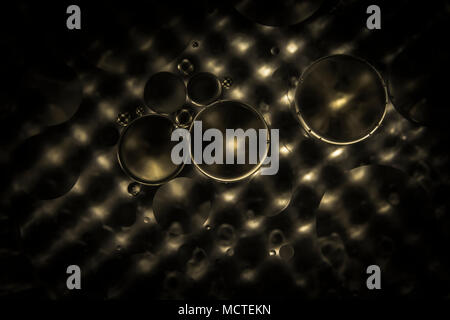 Floating cooking oil on the water inside the saucepan create nice composition and shape in between foreground and background Stock Photo