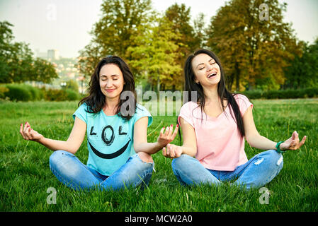 Side view of strong Asian female standing on grass supporting flexible  woman bent in bow pose leaning on arms against hips on blurred background  of park. Photos | Adobe Stock