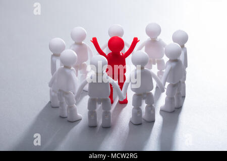 Red Human Figure Surrounded By Team Representing Unity Stock Photo