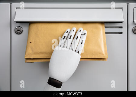 Close-up Of A Robotic Hand Inserting Envelope In Mailbox Stock Photo