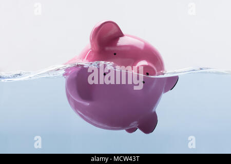 Close-up Of A Pink Piggy Bank Drowning In Water Stock Photo