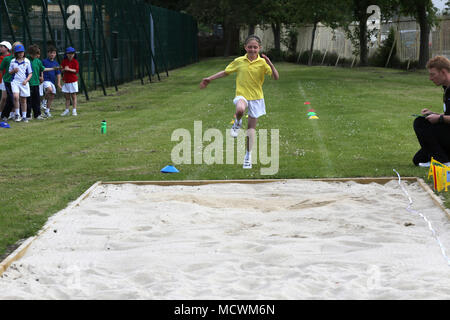 Girl doing the Long Jump at School Sports Day England Stock Photo