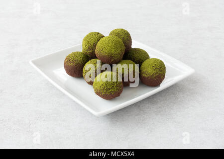 Closeup of homemade green matcha energy balls arranged on a white porcelain plate. Stock Photo