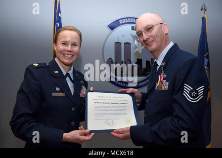 Maj. Alta R. Caputo, the commander of the105th Base Defense Squadron, presents Tech. Sgt. Raymond P. Lucca Jr. with a Certificate of Appreciation at Stewart Air National Guard Base, New York, March 4, 2018. The certificate was given during a ceremony to honor his military career.(U.S. Air Force photo by Airman 1st Class Mary Schwarzler) Stock Photo