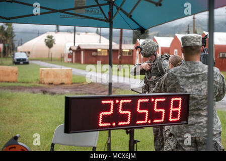 Staff Sgt. Gary G. Olsen-Saville of the 1984th United States Army Hospital Detachment 2 rests after completing the 12-mile ruck march during the Best Warrior Competition at Schofield Barracks, Hawaii Mar. 2, 2018.  The Best Warrior Competition recognizes Soldiers who demonstrate commitment to the Army Values, embody the Warrior Ethos, and represent the Force of the Future. Stock Photo