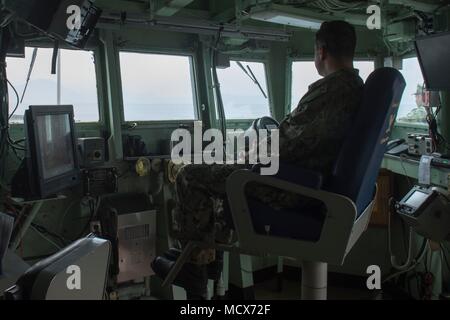 180304-N-QR145-030 NAPLES, Italy (March 4, 2018)  Capt. G. Robert Aguilar, commanding officer of the Blue Ridge-class command and control ship USS Mount Whitney (LCC 20), mans the bridge as the ship departs Naples, Italy, March 4, 2018. Mount Whitney, forward-deployed to Gaeta, Italy, operates with a combined crew of U.S. Navy Sailors and Military Sealift Command civil service mariners.  (U.S. Navy photo by Mass Communication Specialist 3rd Class Krystina Coffey/Released) Stock Photo