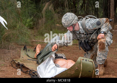 Staff Sgt. Gary G. Olsen-Saville of the 1984th United States Army Hospital Detachment 2 simulates treating a casualty during the Best Warrior Competition at Schofield Barracks, Hawaii Mar. 3, 2018.  The Best Warrior Competition recognizes Soldiers who demonstrate commitment to the Army Values, embody the Warrior Ethos, and represent the Force of the Future. Stock Photo