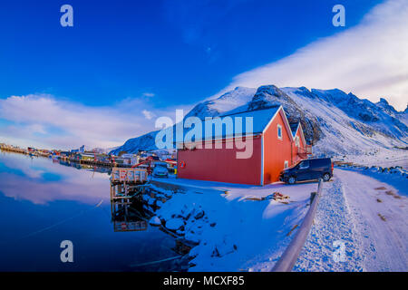 SVOLVAER, LOFOTEN ISLANDS, NORWAY - APRIL 10, 2018: Outdoor view of cars parked at red rorbu or fisherman's houses close to the port in Svolvaer Lofoten Islands Stock Photo