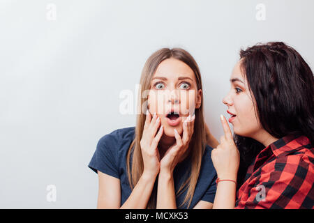 Close up fashion lifestyle portrait of two young hipster girls best friends, making funny faces and have gray time.  Space for text Stock Photo