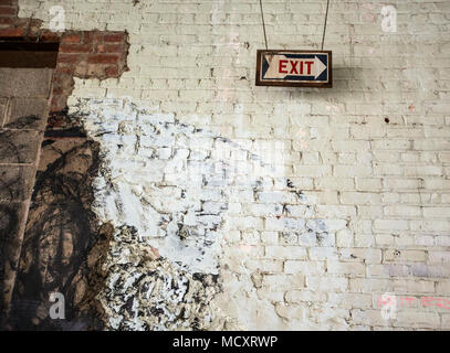 Exit sign on the interior wall of an old factory Stock Photo