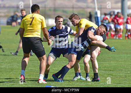 Petty Officer 3rd Class Ryan McManus, from Coast Guard Sector Detroit, tackles a Western Michigan rugby player during a sevens rugby match against Team Quebec, Canada, at the Las Vegas Invitational, the largest rugby tournament in North America, March 1, 2018. More than 275 teams competed across 28 divisions over the annual multi-day event, which ran alongside the USA Sevens international rugby tournament. (U.S. Coast Guard photo by Petty Officer 1st Class Rob Simpson/released) Stock Photo