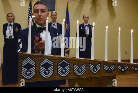 Chief Master Sgt. Claudio Castillo, 81st Surgical Operations Squadron superintendent, lights a candle during a candle lighting ceremony during the Chief Induction Ceremony at the Bay Breeze Event Center March 1, 2018, on Keesler Air Force Base, Mississippi. Three Keesler Airmen earned their chief master sergeant stripe during the 2018 promotion release. (U.S. Air Force photo by Kemberly Groue) Stock Photo