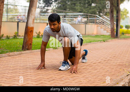 Young athlete in the ready position before going for a run Stock Photo