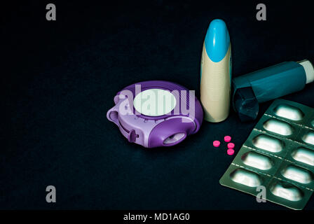 Set of asthma inhaler, accuhaler and anti-allergy pills for treatment asthma. Asthma controller, reliever equipment on dark table with copy space. Bro Stock Photo