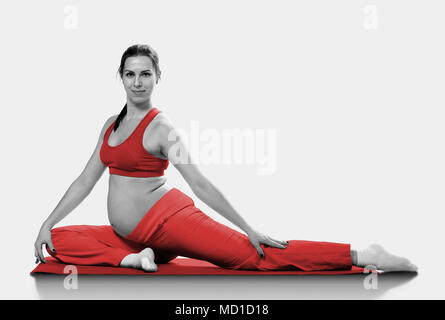Pregnant woman making exercise, isolated on grey Stock Photo
