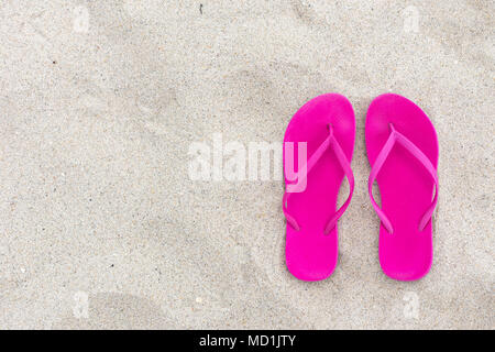 Summer background pink flip lops on the sand, beach day vacation and holiday concept flat lay from high angle design room for text Stock Photo