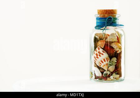 Sand and shells in bottle on white background. Free space for your text. Stock Photo