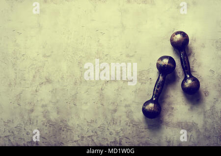 Old dumbbells on concrete background. Sport concept. Free space for your text Stock Photo