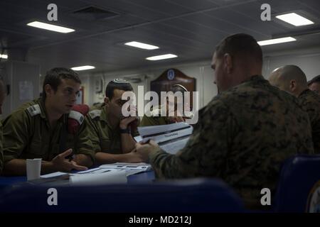 180306-M-IZ659-0007 MEDITERRANEAN SEA (Mar. 6, 2018) U.S. Marine Corps leadership of Battalion Landing Team, 2nd Battalion, 6th Marine Regiment (BLT 2/6), 26th Marine Expeditionary Unit (MEU), discuss details about the upcoming bilateral exercise Juniper Cobra with Israeli Defense Force (IDF) soldiers aboard the Wasp-class amphibious assault ship USS Iwo Jima (LHD 7), Mar. 6, 2018. JC18 is a combined exercise designed to improve interoperability between US and Israeli forces. (U.S. Marine Corps photo by Cpl. Santino D. Martinez/Released) Stock Photo