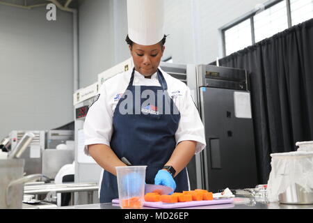 Joint Culinary Training Exercise is an annual military culinary competition conducted at Fort Lee, Virginia, by the Joint Culinary Center of Excellence. On March 14, 2018, during the 43rd annual event, a student chef segment featured early-career service members preparing ingredients at the MacLaughlin Fitness Center. The archival image documents food preparation during the competition. Stock Photo