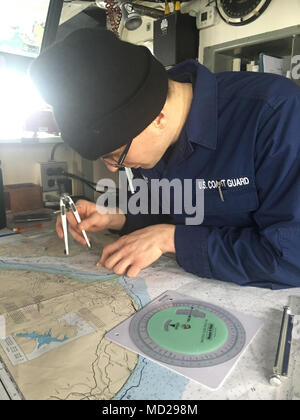 A Coast Guard Cutter Naushon (WPB 1311) crew member practices plotting navigational points on the Naushon in Homer, Alaska, March 6, 2018. The Tailored Ship's Training Availability tests the crew on every aspect of operational readiness. U.S. Coast Guard photo. Stock Photo