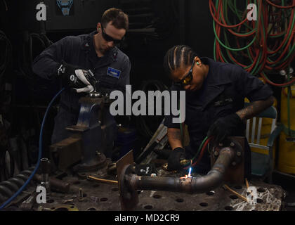 180316-N-NM917-094 YOKOSUKA, Japan (March 16, 2018) -  Hull Maintenance Technician 2nd Class Jacob Johnson, from Huntsville, Texas, left, and Hull Maintenance Technician Fireman Cola Parsley, from New York City, perform repairs in the repair shop onboard USS Blue Ridge (LCC 19). Blue Ridge and her crew have now entered a final upkeep and training phase in preparation to become fully mission capable for operations.(U.S. Navy photo by Mass Communication Specialist 2nd Class Jordan KirkJohnson /RELEASED) Stock Photo