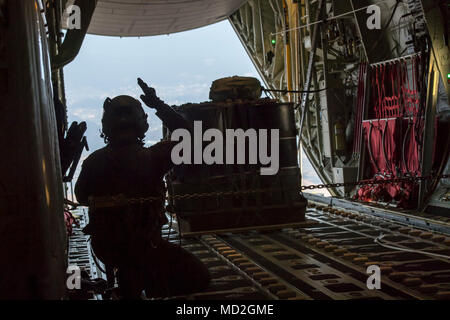 Airman 1st Class Matthew Pfeffer, 36th Airlift Squadron C-130J loadmaster, performs a Container Delivery System (CDS) bundle airdrop over Combined Arms Training Center Camp Fuji, Japan, March 26, 2018. CDS are most commonly used for quick aerial insertion of supplies for military and contingency operations. Bundles are used as a means of delivering equipment too heavy for the individual jumper to carry. Stock Photo