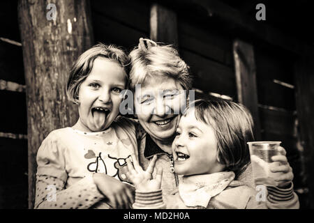 Portrait of Grandmother spending happy time with her granddaughters, outdoor. Stock Photo