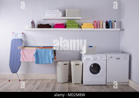 Interior Of Utility Room With Washing Machine And Drying Clothes Stock Photo