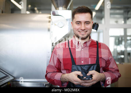 Photo of smiling businessman with phone in hands near roaster Stock Photo