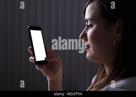Young Woman Using Mobile Phone With Blank White Screen Stock Photo