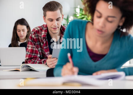 Student smiling while using a tablet during class Stock Photo
