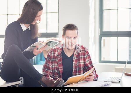 Two cheerful students checking information and knowledge Stock Photo