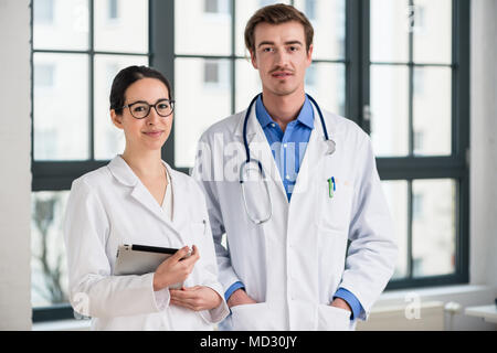 Two dedicated doctors smiling at camera Stock Photo