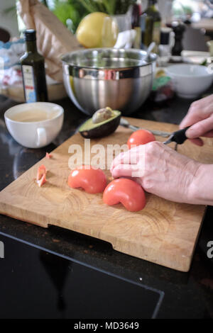 Cooking at home.Person chopping fresh tomatoes. Stock Photo