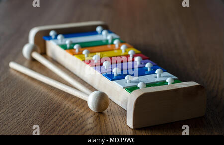 Rainbow coloured xylophone on wooden background angle view. metallophone with soft focus effect Stock Photo