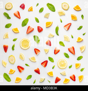 Flat lay of chaotic seamless background with slices of fresh citrus and strawberry in composition with banana and mint leaves. Stock Photo