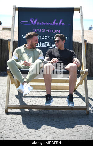 Brighton UK 18th April 2018  - Dean Ralph and Jordan Wright find a huge deckchair to relax in as they take a break from filming the reality television show The Only Way is Essex on Brighton seafront in hot sunshine today Credit: Simon Dack/Alamy Live News Stock Photo