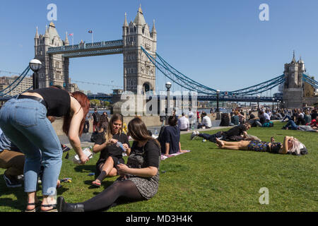 London, UK. 18th Apr, 2018.  People enjoying the sunshine alongside the River Thames, with Tower Bridge in the background, on one of the hottest days of the year so far.  The warm weather is forecasted to last for the rest of the week.  Credit: Milton Cogheil/Alamy Live News Stock Photo