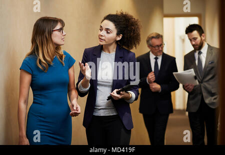 Business team walking and talking along office corridor Stock Photo