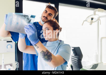 Two dentists in dentist office, looking at dental x-ray Stock Photo