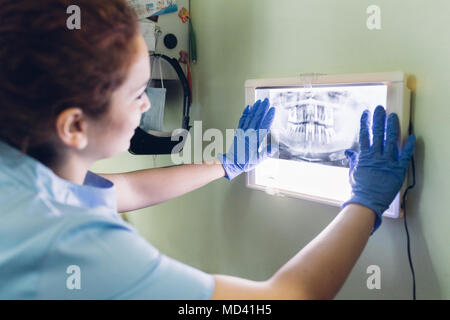 Female dentist looking at dental x-ray on lightbox Stock Photo