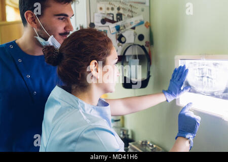Two dentists in dentist office, looking at dental x-ray Stock Photo