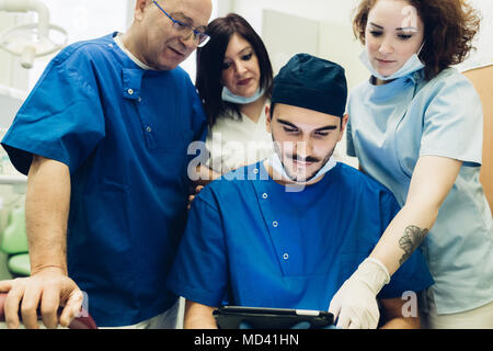 Dentists in dentist office looking at digital tablet Stock Photo