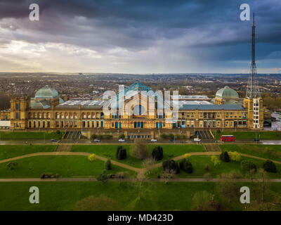 London, England - Aerial panromaic view of Alexandra Palace in Alexandra Park with iconic red double-decker bus and dramatic clouds behind Stock Photo