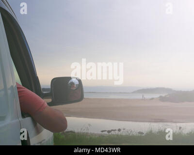 Senior man sitting in car, looking at coastal view, Broulee, New South Wales, Australia Stock Photo