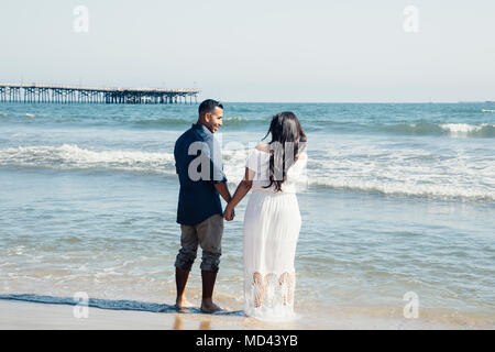 Couple standing on beach, holding hands, rear view, Seal Beach, California, USA Stock Photo