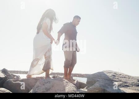 Couple standing on coastal rock, low angle view, Seal Beach, California, USA Stock Photo